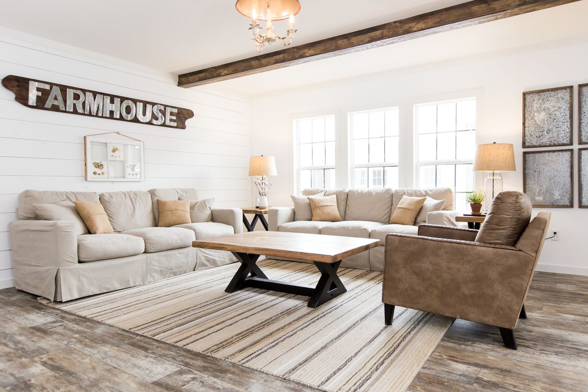 A living room with a farmhouse sign on the wall.