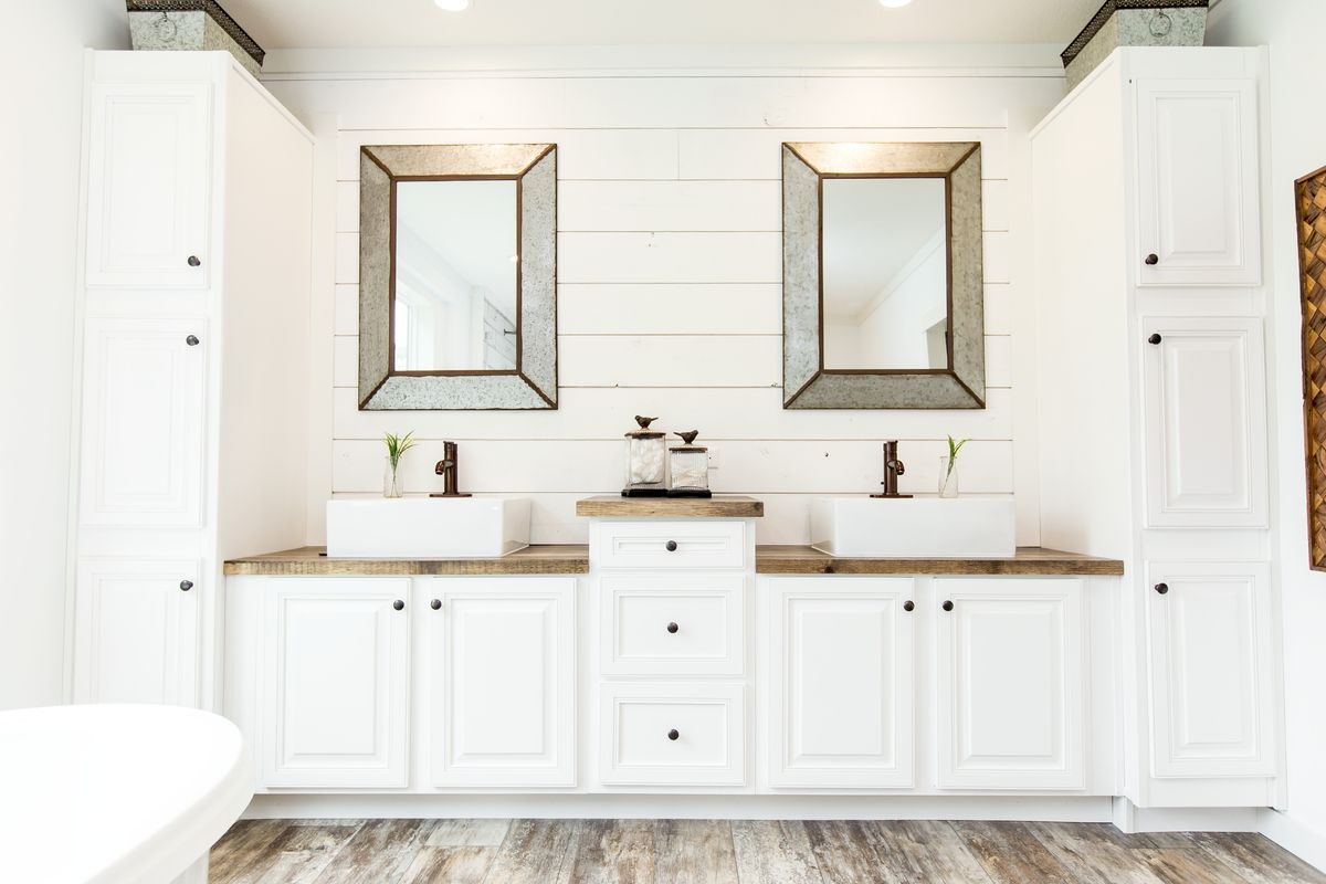 A white bathroom with two sinks and mirrors.