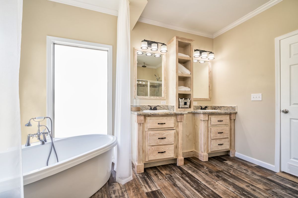 A bathroom with wood floors and a tub.