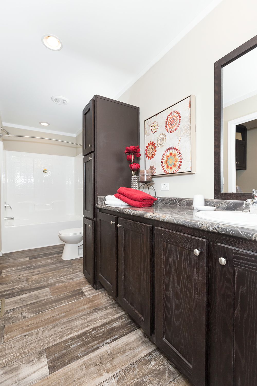 null A bathroom with dark wood cabinets and tile floors.