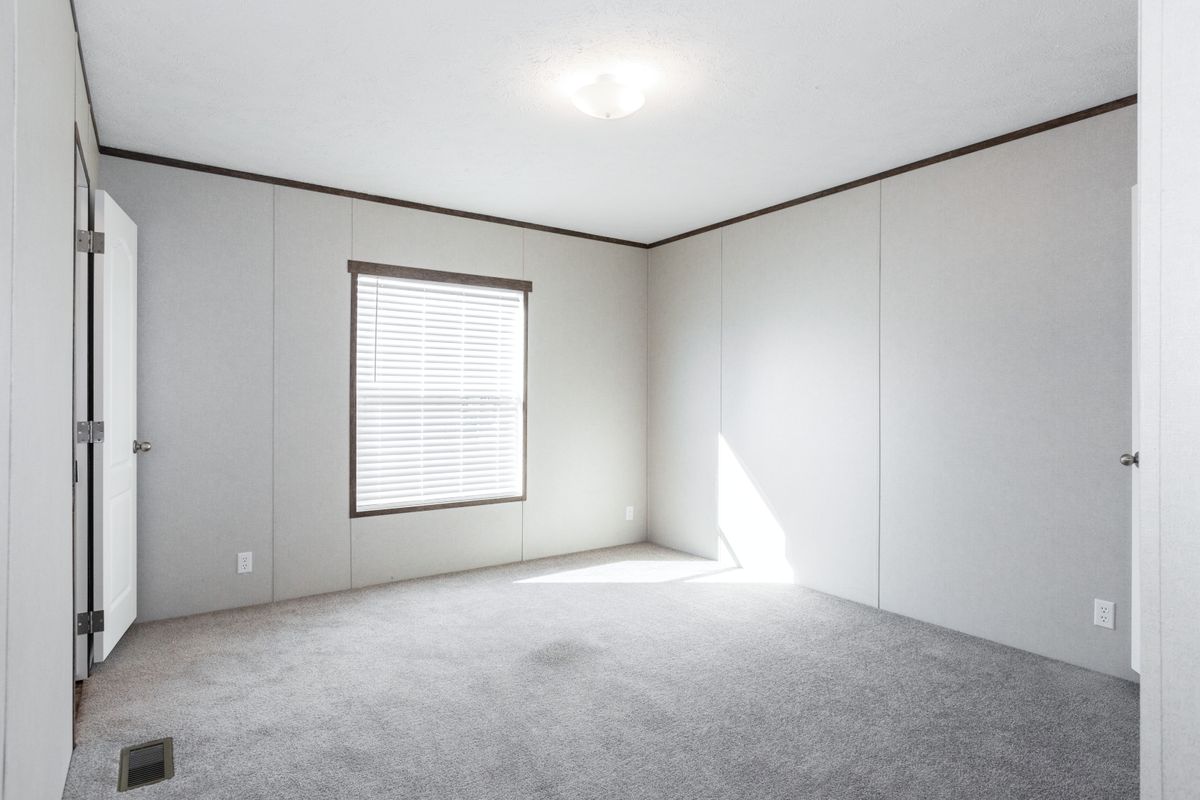 a1da94d3-79b1-424a-ad30-5ecab0a6c4be An empty room with carpet and a window.