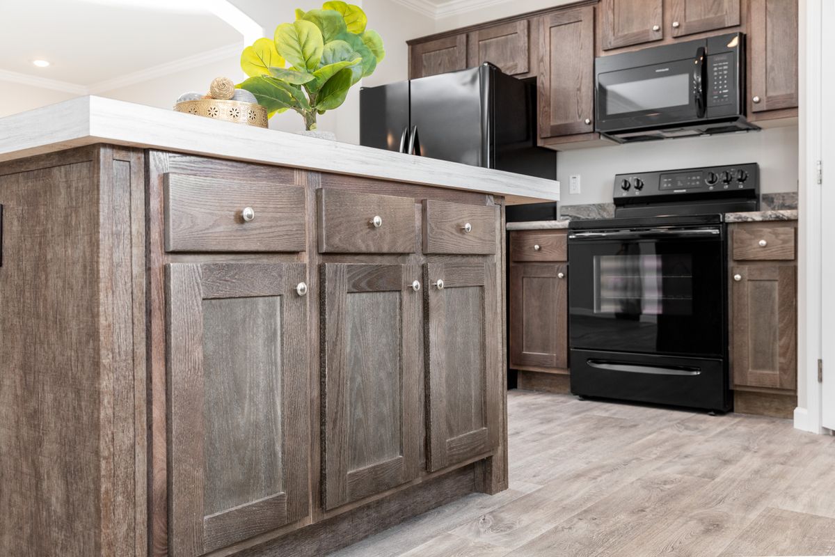 a300b968-c586-4ffe-8a06-cfa07e5c3991 A kitchen with wood cabinets and stainless steel appliances.