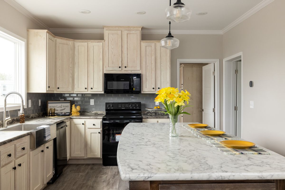 a4673569-d5d4-4108-b4b5-7f198fb5c16e A kitchen with white cabinets and marble counter tops.