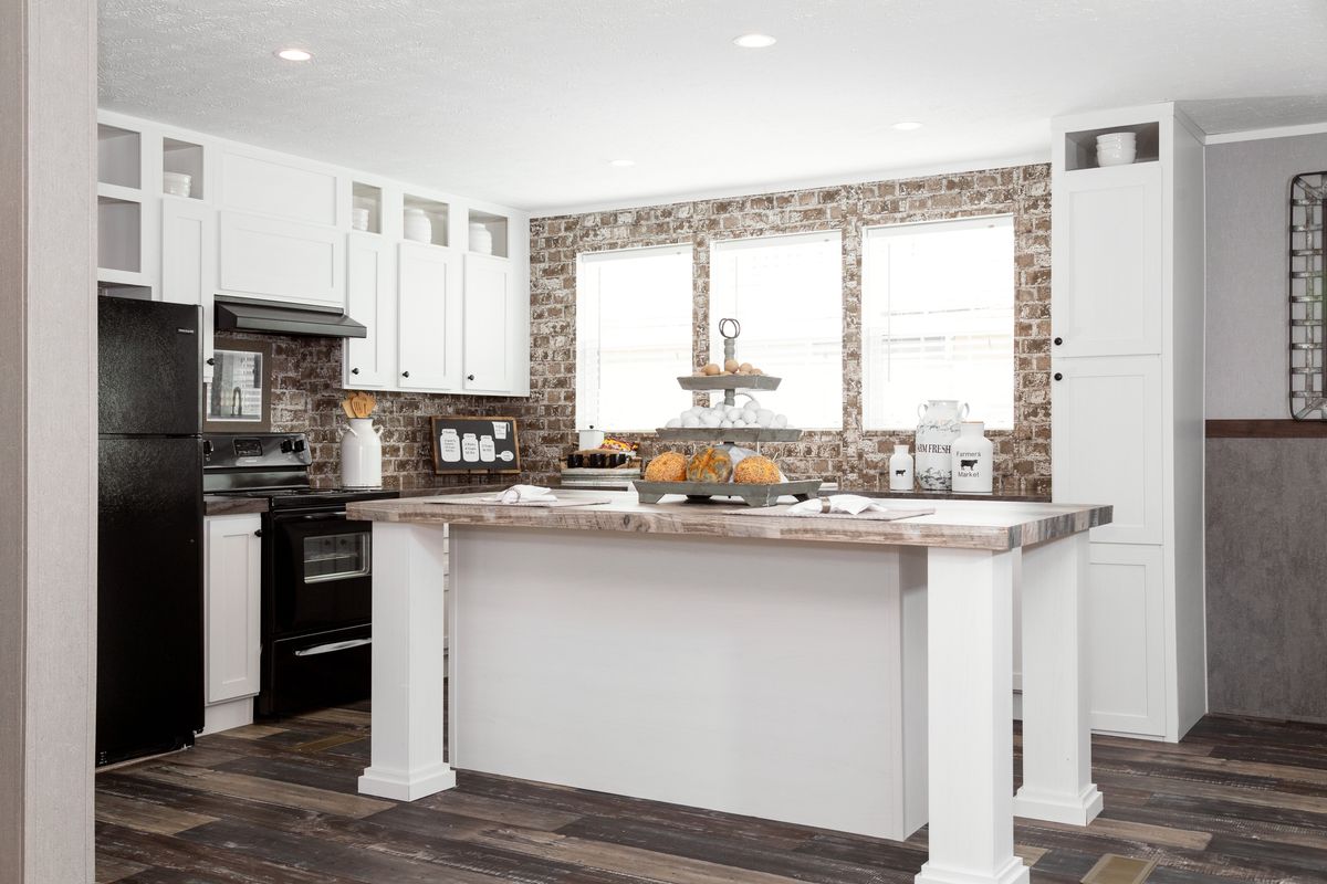 a9f4d4cb-f38d-40cf-a523-1ce6ed454d0f A kitchen with white cabinets and wooden floors.