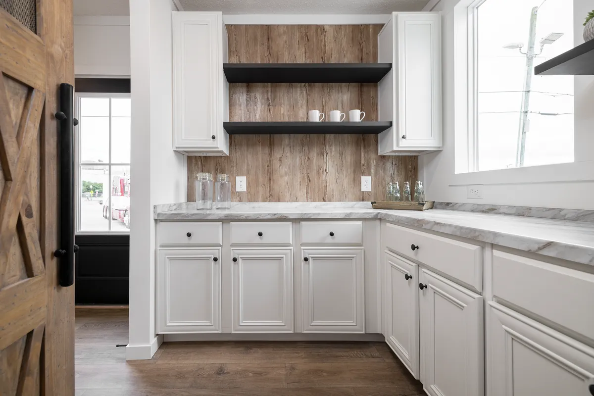 aa0a0e81-c989-4c12-a760-d40c194102a8 A white kitchen with wood cabinets and a wooden door.