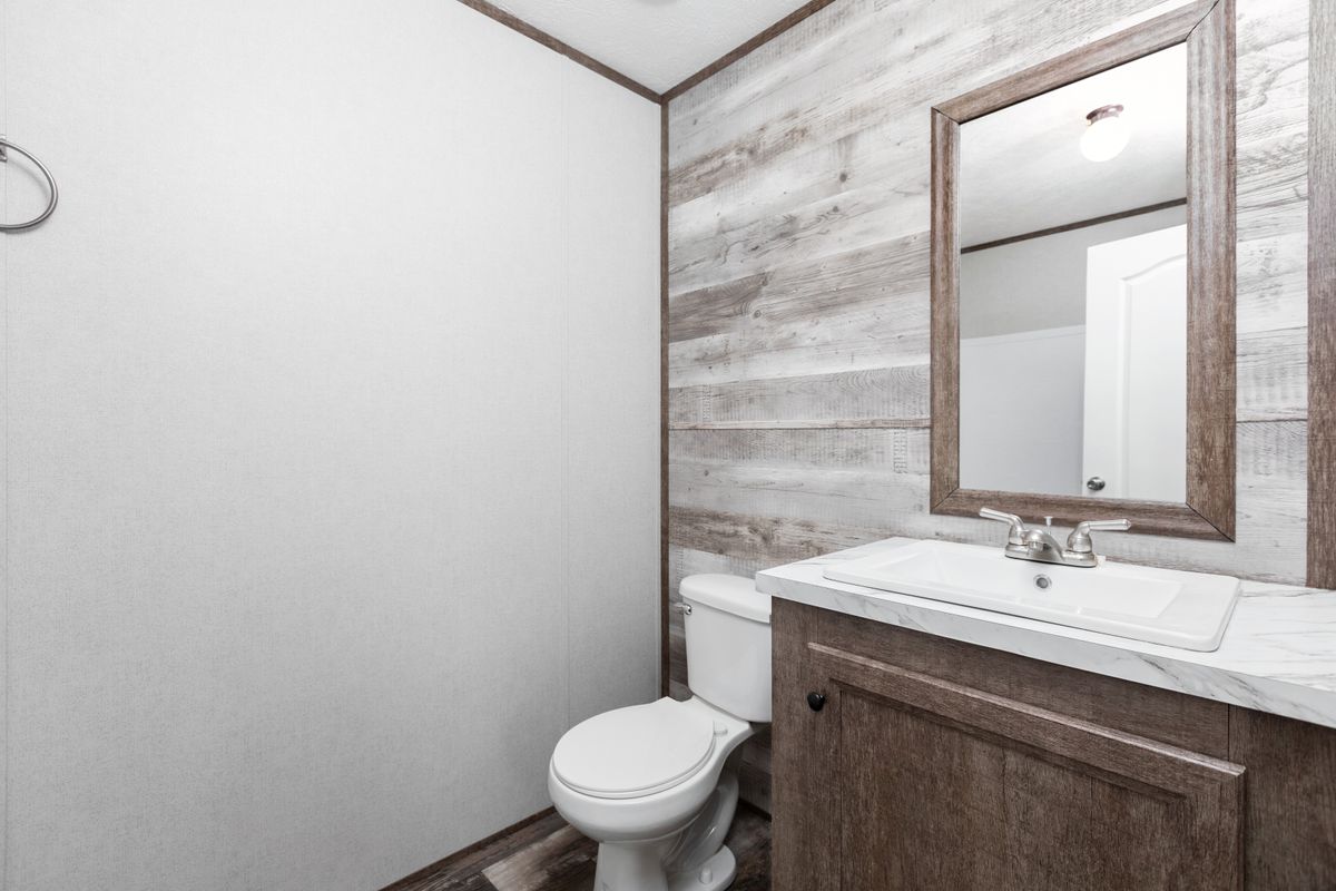 A bathroom in a mobile home with a toilet and sink.