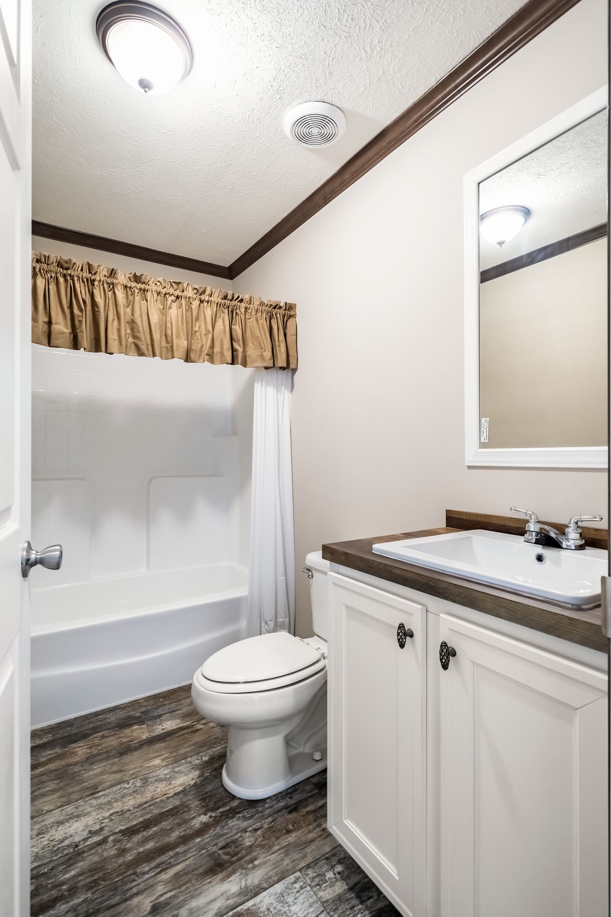 A bathroom with a toilet, shower, and sink.