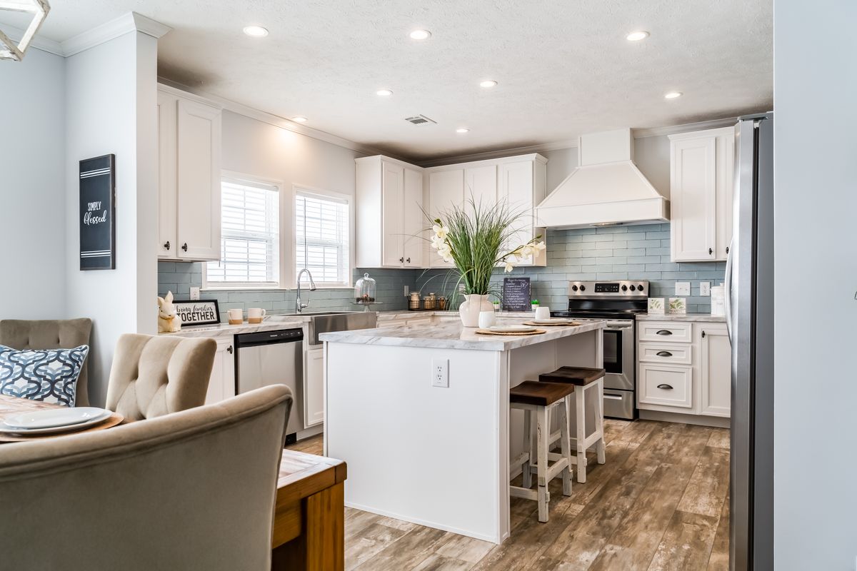 adc694bc-bbaf-4926-b755-b9e39199dc0f A kitchen with white cabinets and hardwood floors.