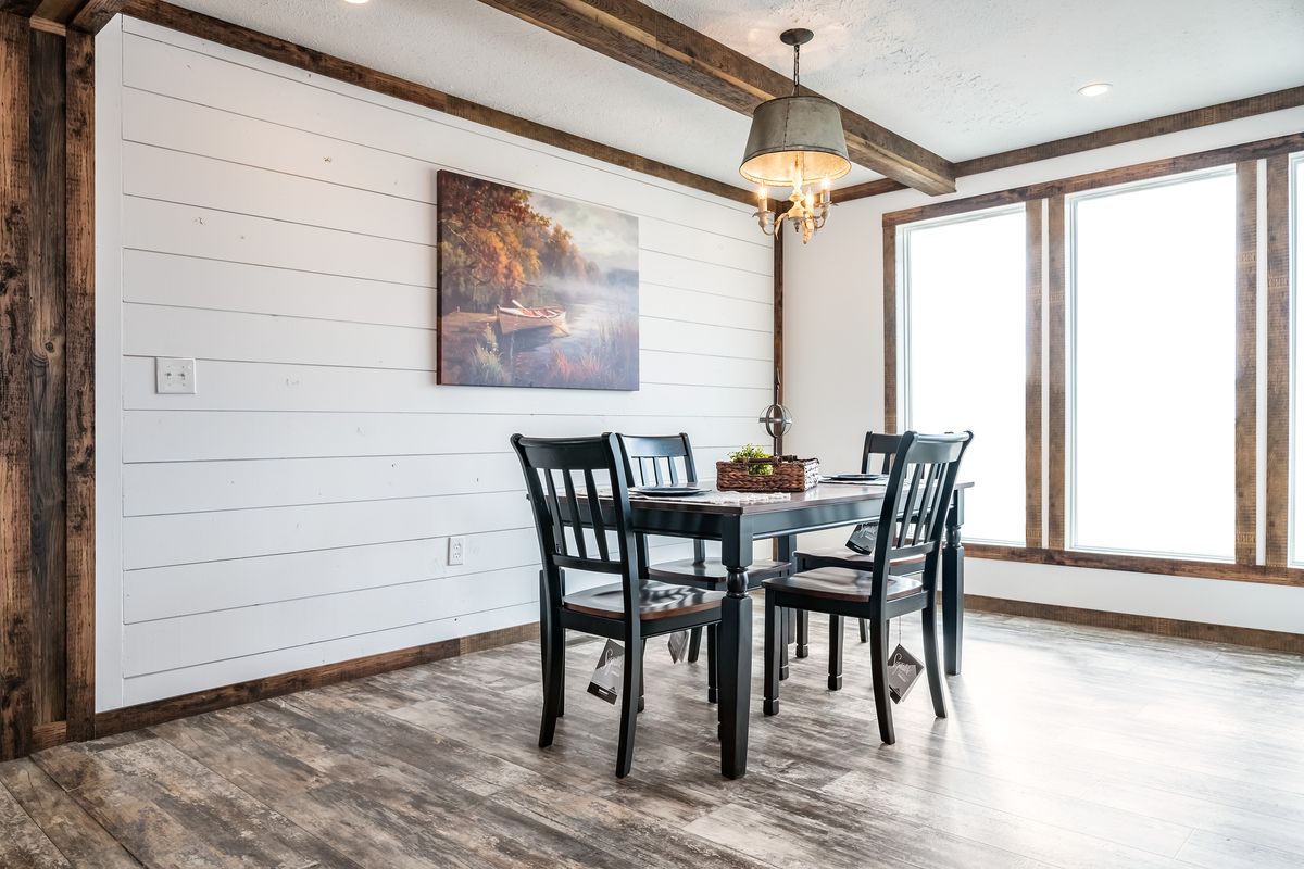 A dining room with wood floors and a wooden table.