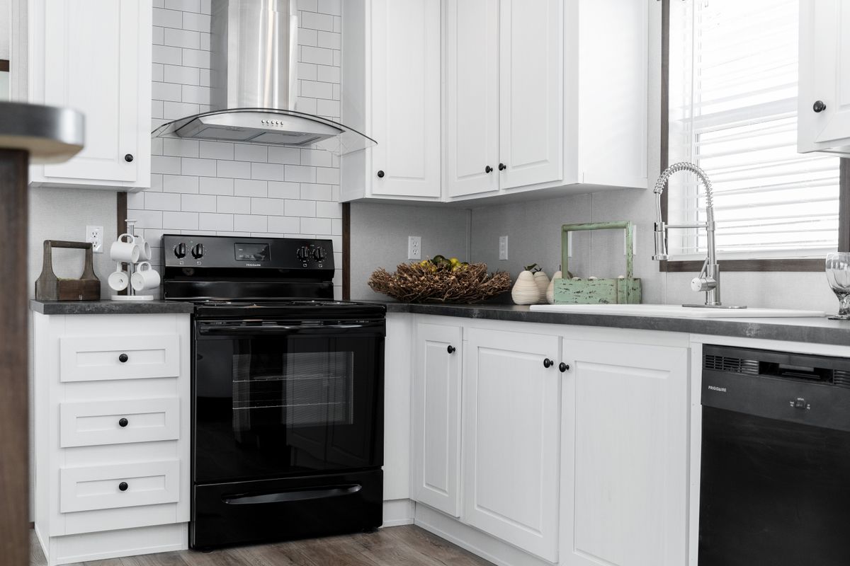 A kitchen with white cabinets and black appliances.