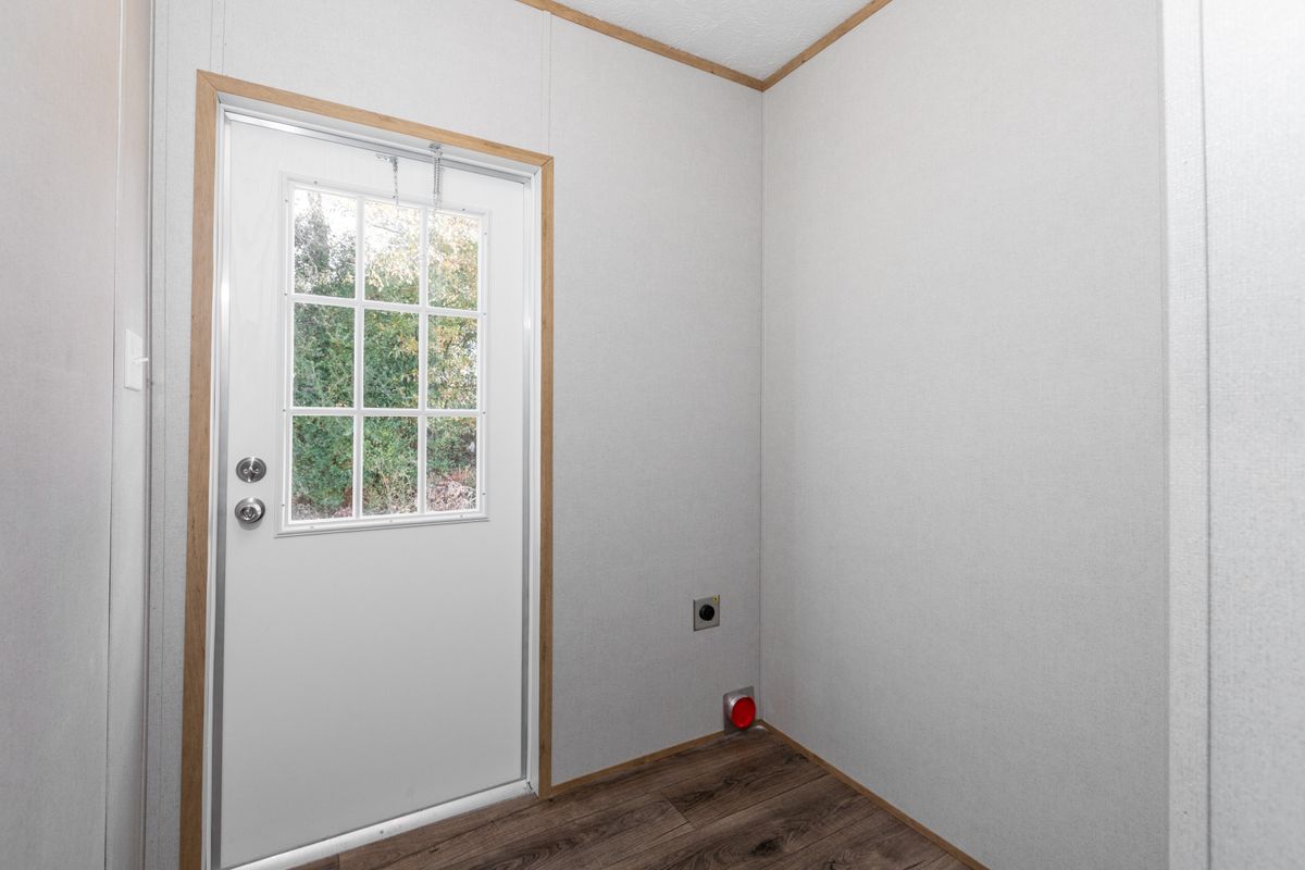 A small room with wood floors and a door.