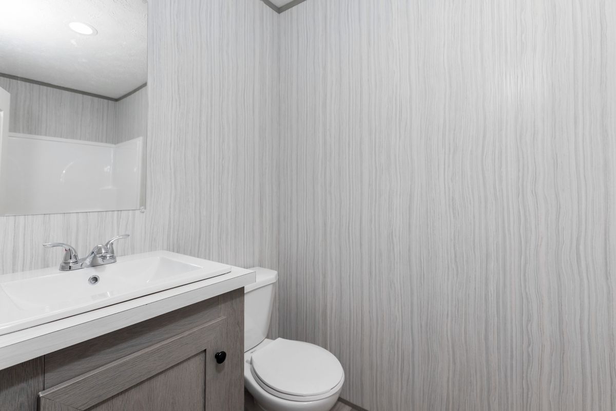 b1cf0a27-2584-42f7-9a40-208a6cf96fdf A small bathroom with a toilet and sink.