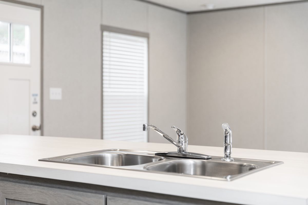 b60f6e0d-f5d7-412d-adf2-7cbe757dd1a9 A kitchen in a mobile home with a sink.