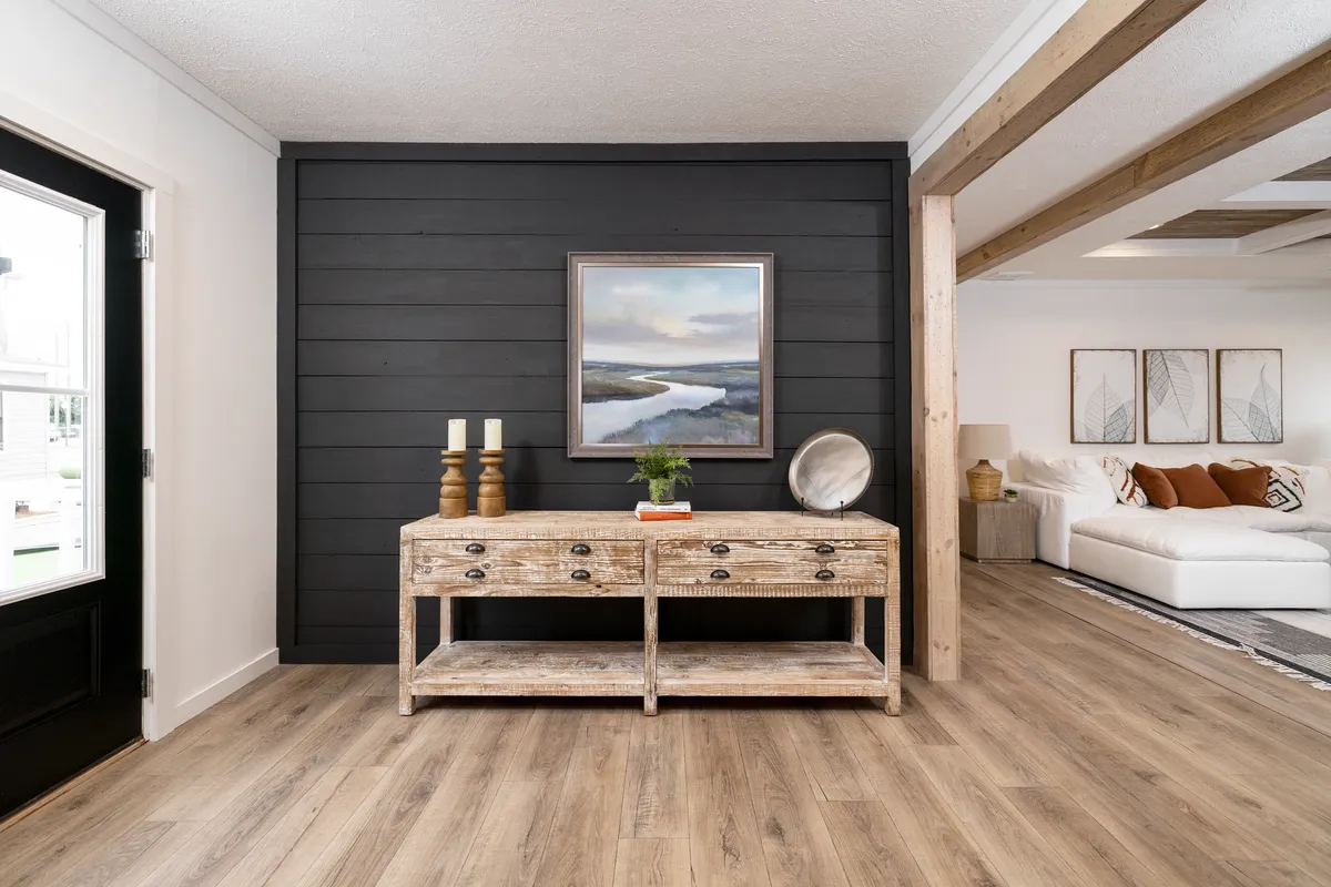 ba3a8a3c-fc32-4256-939a-dde0f9c8f477 A living room with black walls and wood floors.