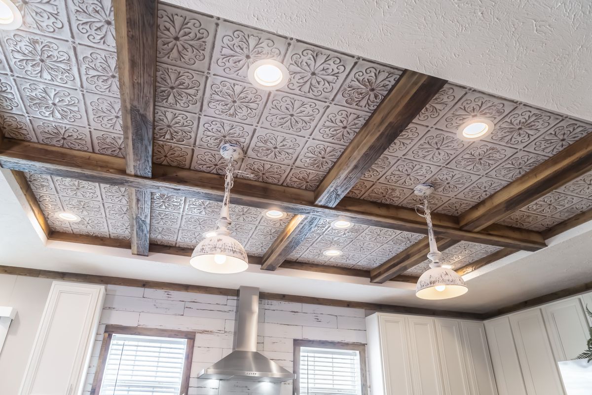A kitchen with a wooden ceiling and lights.