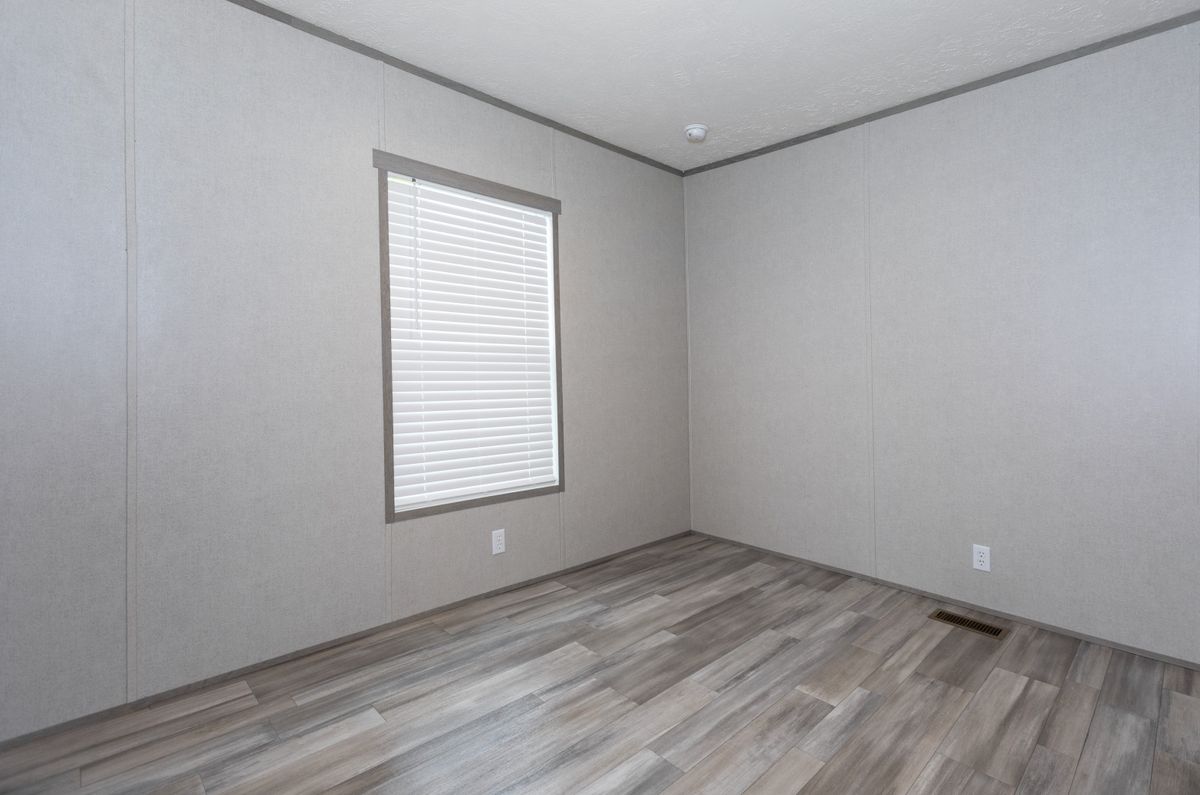 ba46f02a-0bf7-4bee-8417-66b15f14352c An empty room with wood floors and a window.