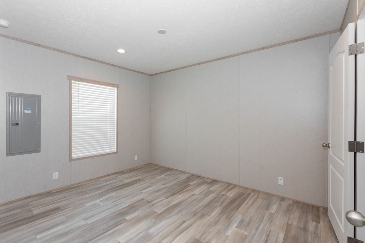 ba9c65ac-962f-4e2d-bf71-2c15f526fac3 An empty room with wood floors and a window.