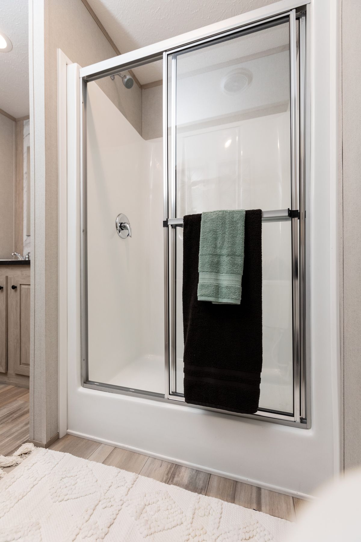 bab3f0c3-65bc-46ad-9fd5-def86b623297 A bathroom with a glass shower door.