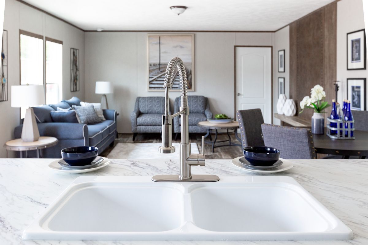 bc89e5bb-f28e-4493-881c-6aa7b8f0e8fe The kitchen of a mobile home with a marble counter top.
