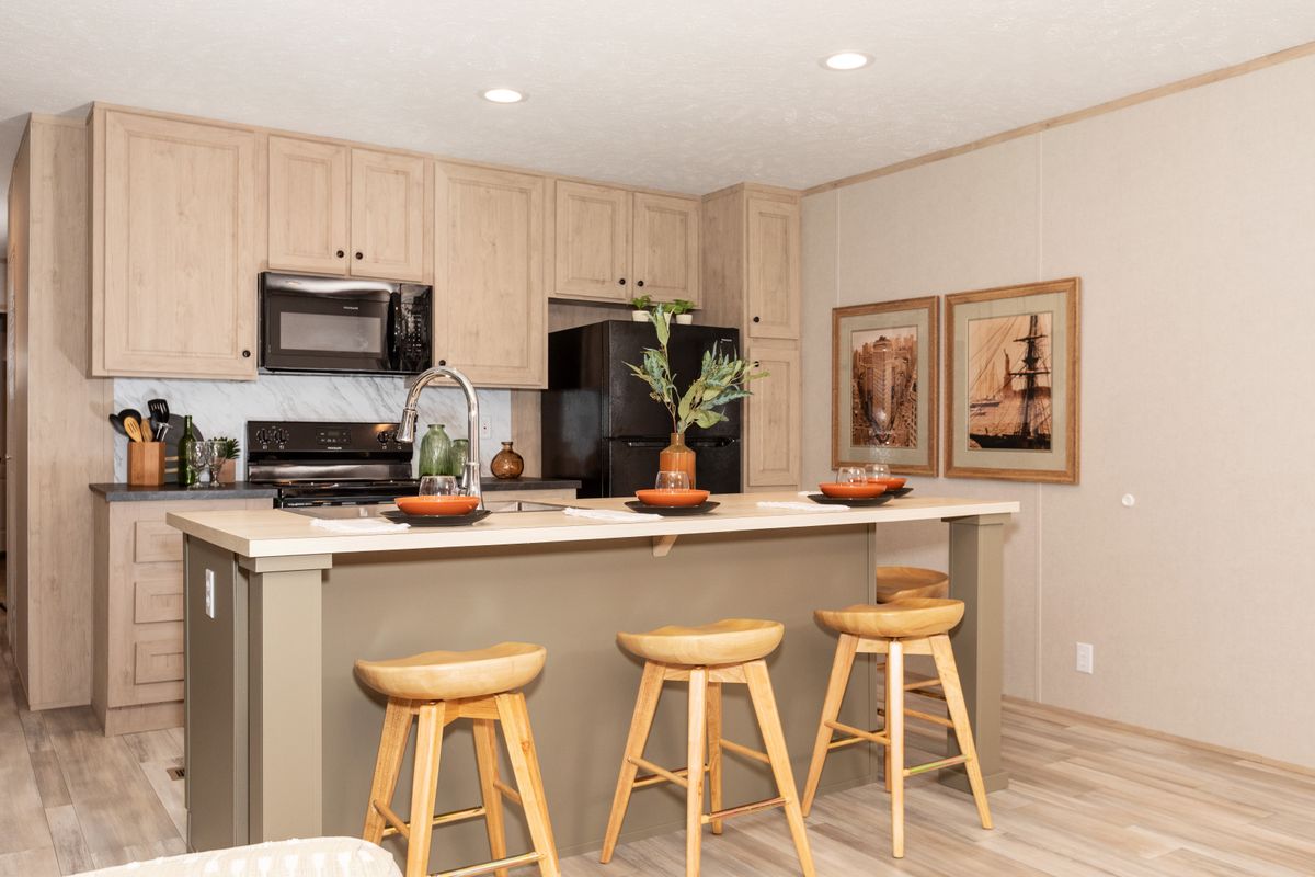 bf6da121-b4e6-41df-83f6-248d4f163efa A kitchen in a mobile home with bar stools.