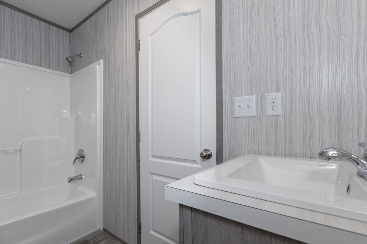 bfe94513-d4e0-4812-82be-ed168848a3fd A bathroom with a sink, toilet and shower.