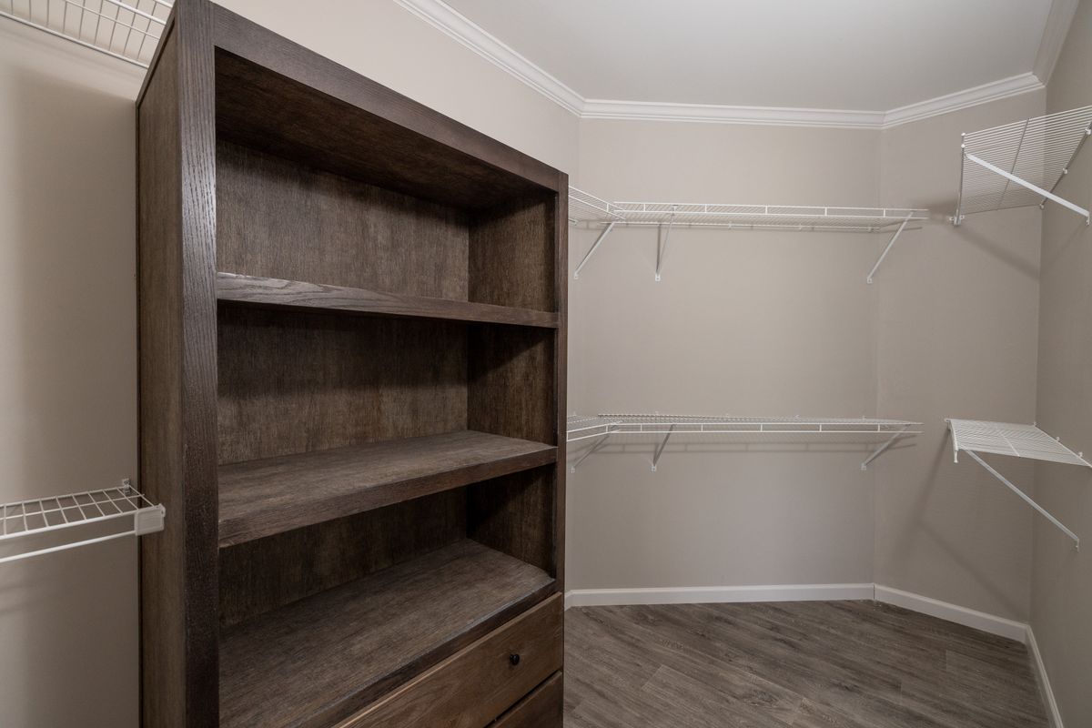 c405e69e-7ae3-4fc0-ae43-9471c5c5e91f A walk in closet with shelves and a bookcase.