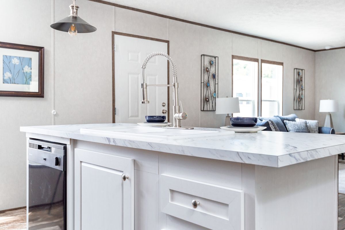c415252b-9698-46c3-982b-dbf98ad0f928 A kitchen in a mobile home with a white island.