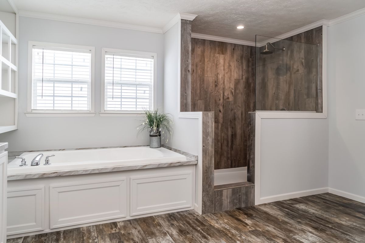 30CEE16682AH
Clayton Waycross Facility 930 A white bathroom with wood floors and a tub.