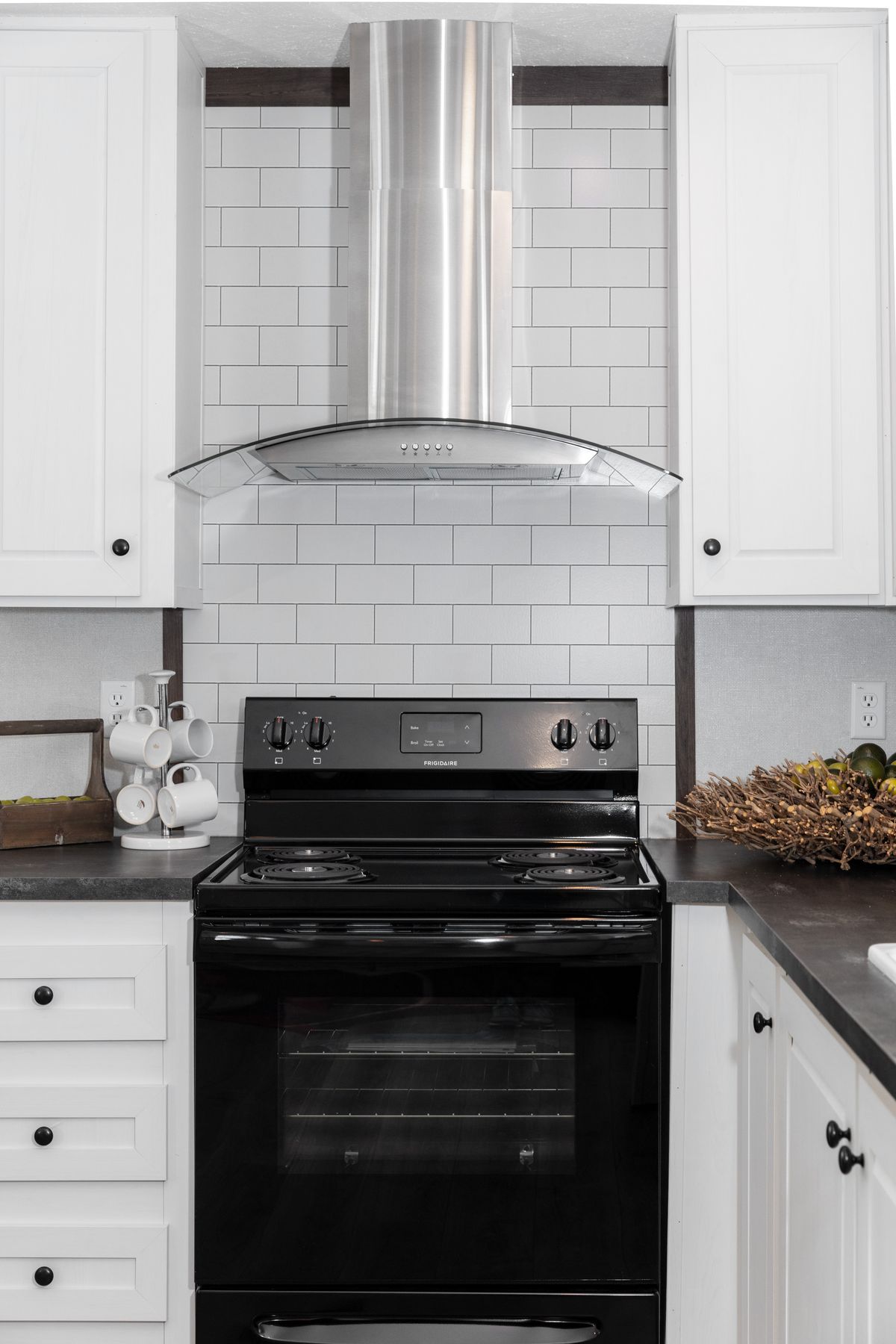 A kitchen with a black stove and white cabinets.