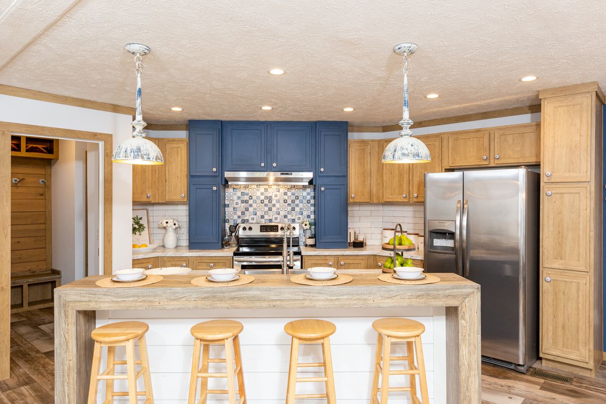 A kitchen with blue cabinets and stools.