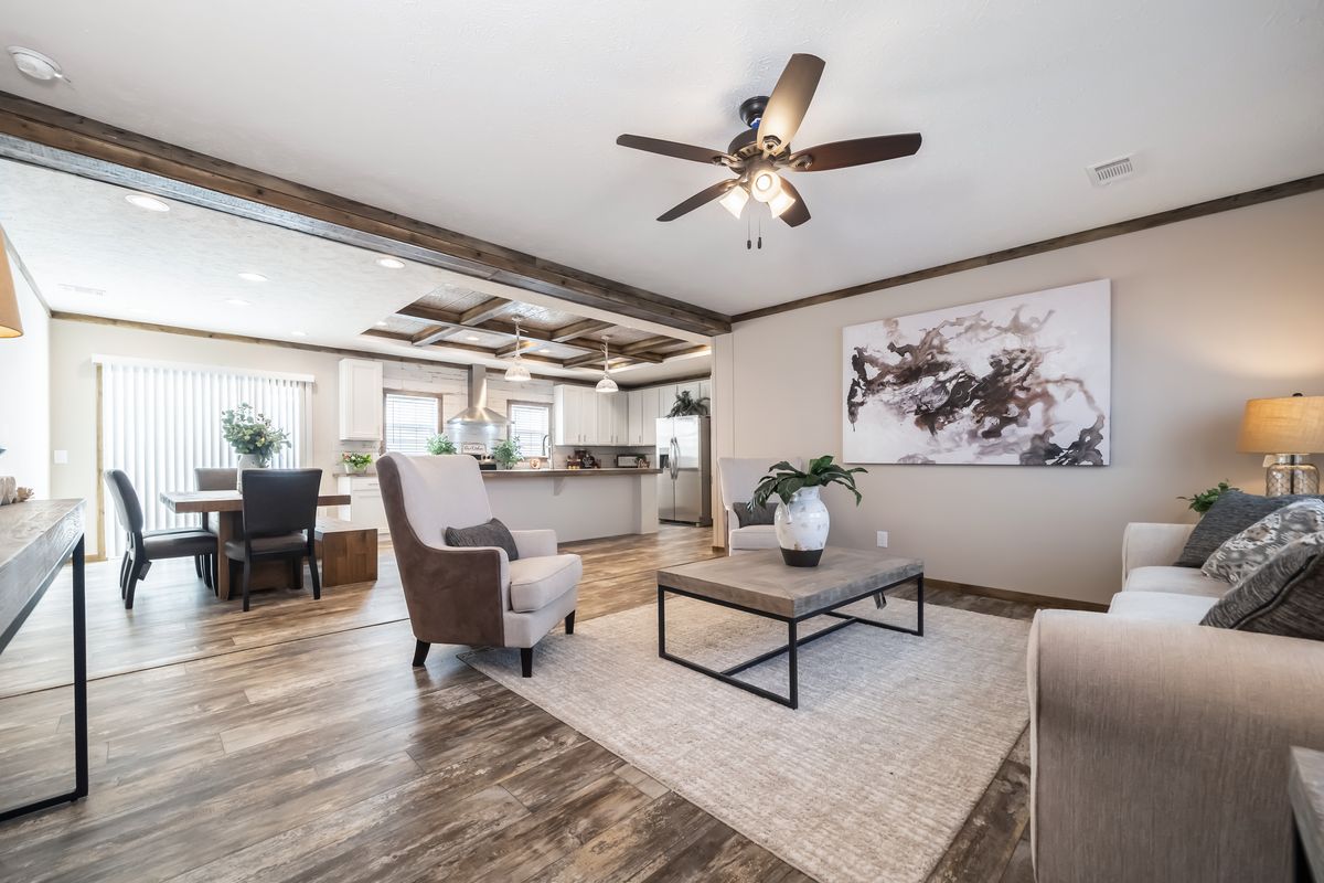 A living room with hardwood floors and a ceiling fan.