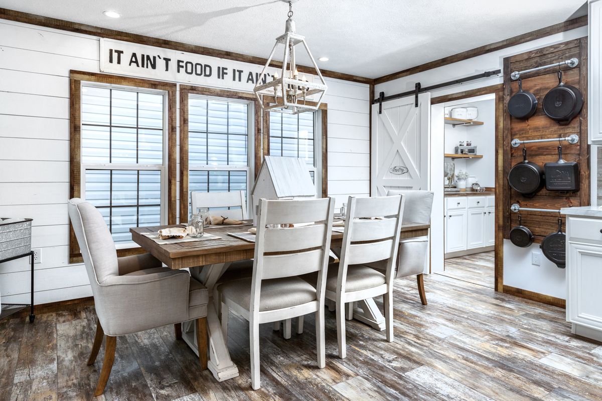 A dining room with a wooden table and chairs.