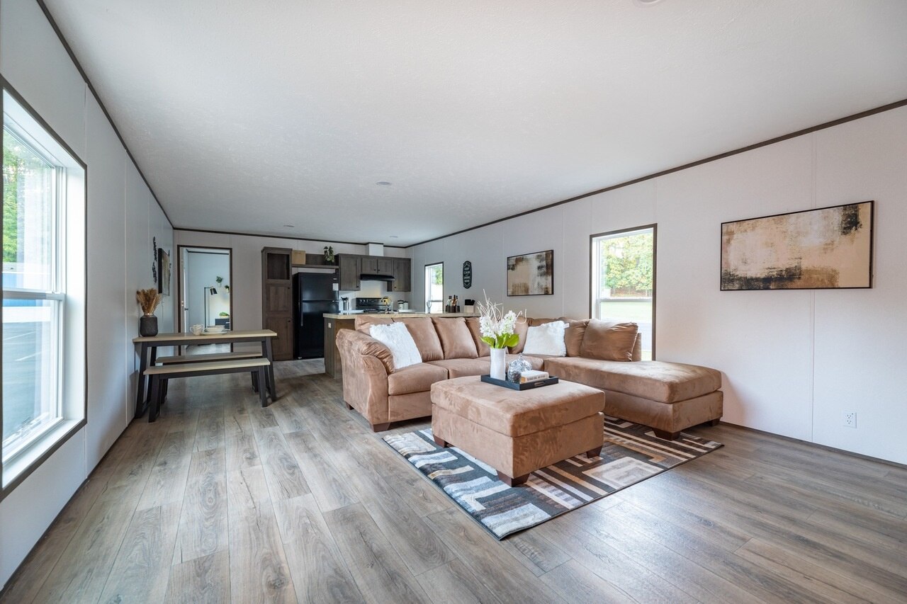 A living room in a mobile home with hardwood floors.