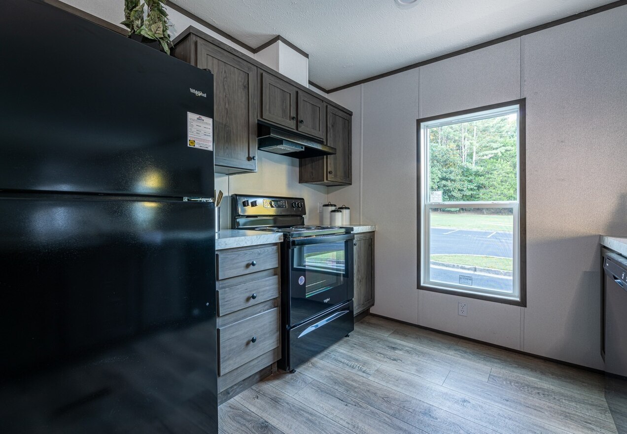 A kitchen in a mobile home with black appliances.