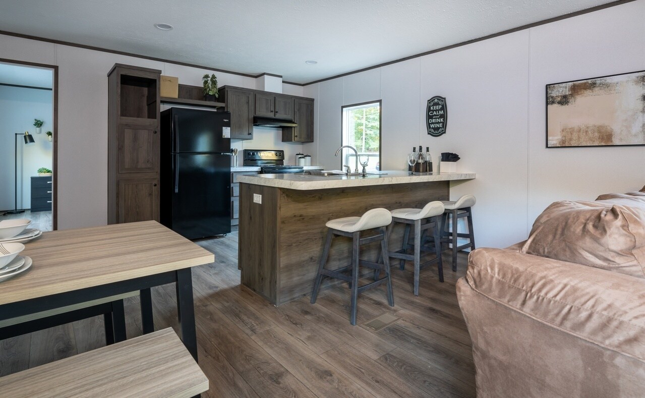A kitchen and living room in a mobile home.