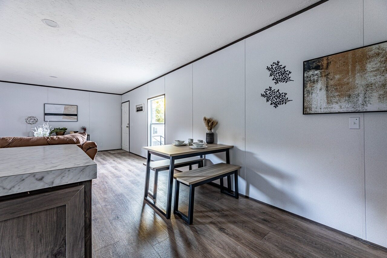 A living room and dining room in a mobile home.