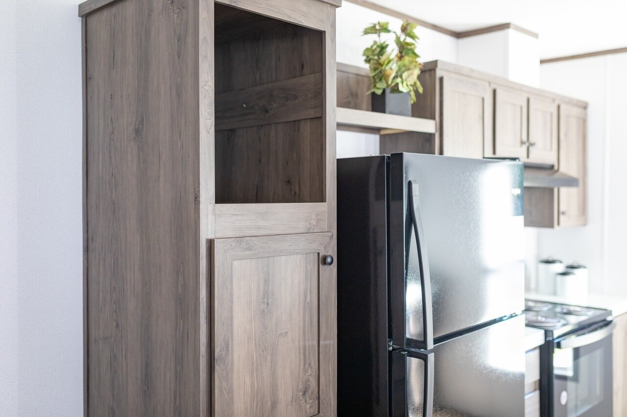 A kitchen with a black refrigerator and wooden cabinets.