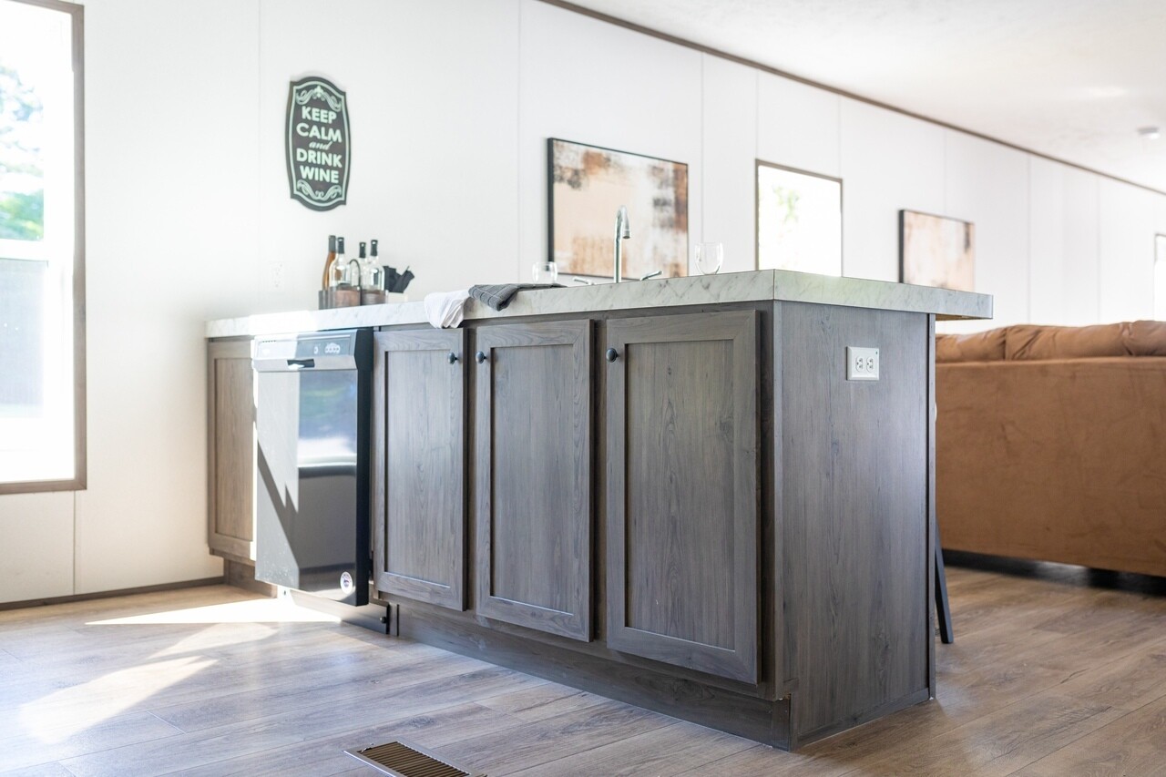 A kitchen in a mobile home with hardwood floors.
