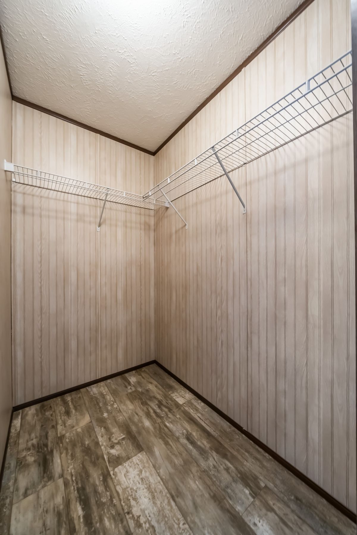 A closet with a wooden floor and wooden walls.