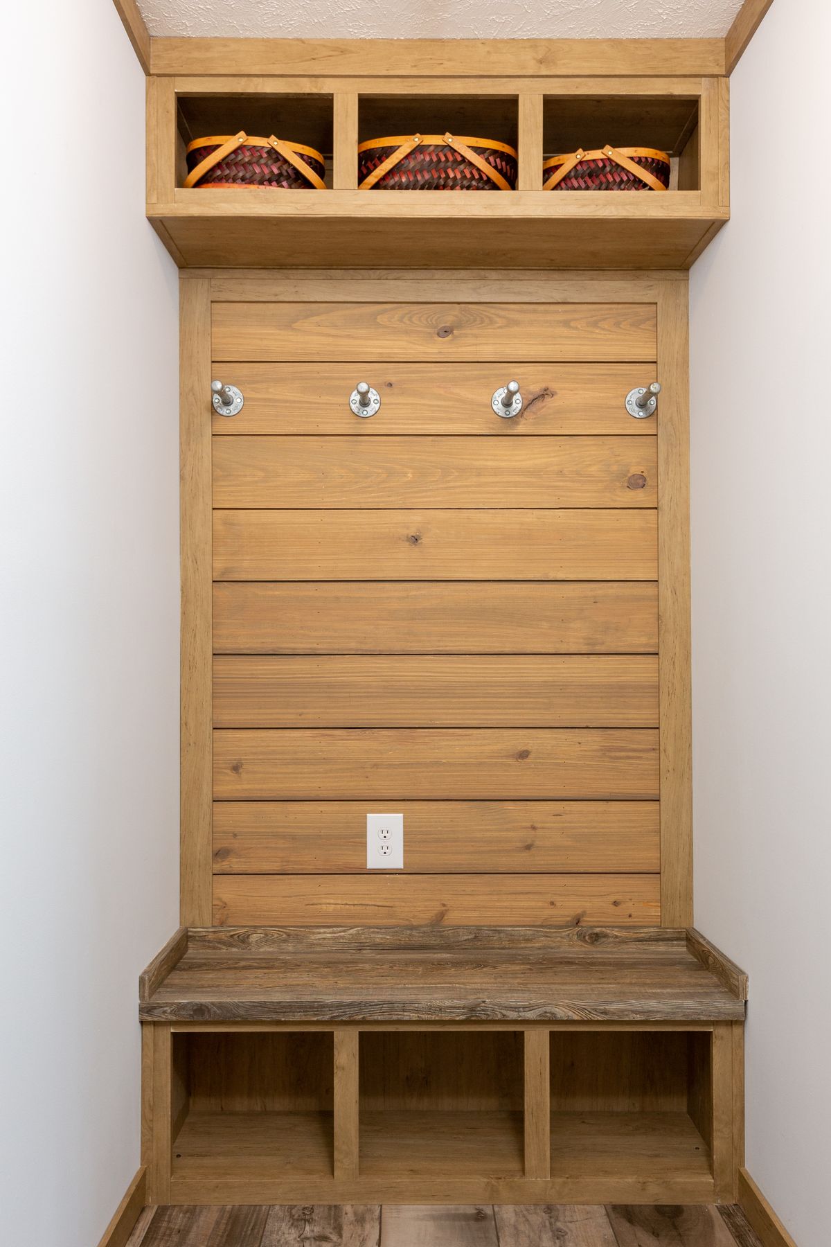 A small mudroom with a bench and baskets.