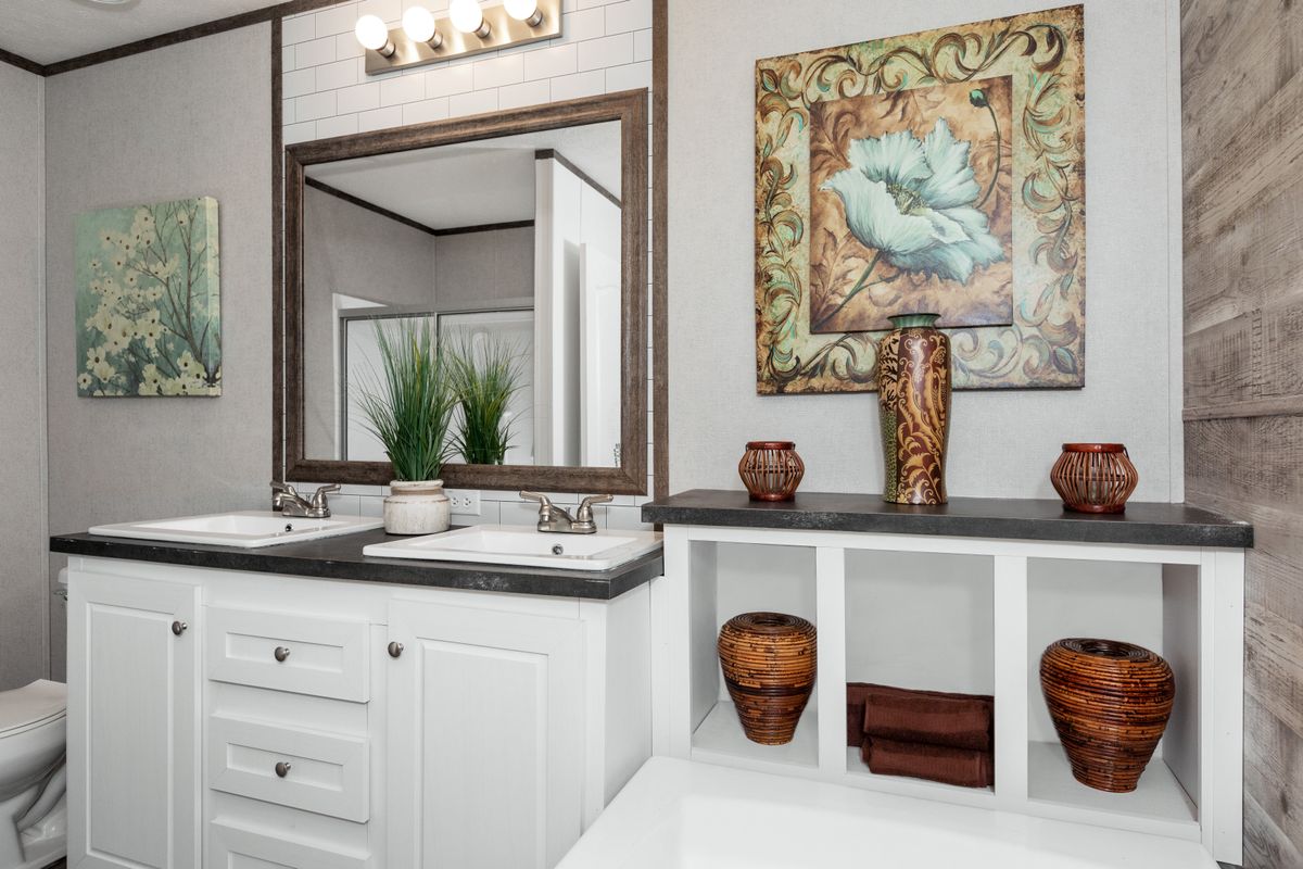 A bathroom with a sink, toilet and mirror.