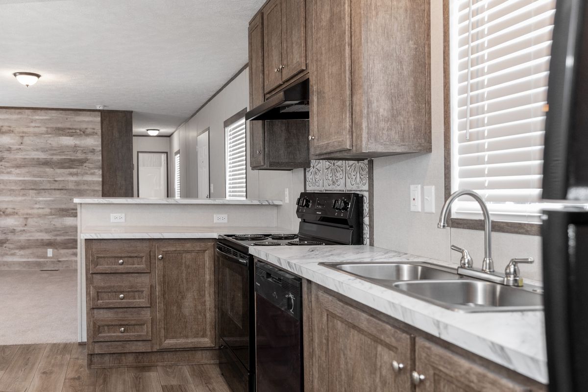 cf2cb6a2-69ee-44ba-95e7-4027b4f50ab5 A kitchen in a mobile home with wood floors.