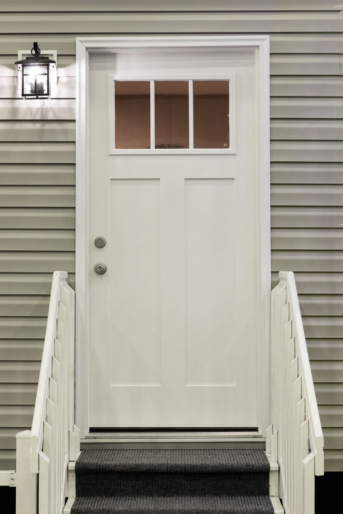 cf72ccdc-fbf8-48aa-b4b4-e0eb7f294839 A white front door with a light on it.