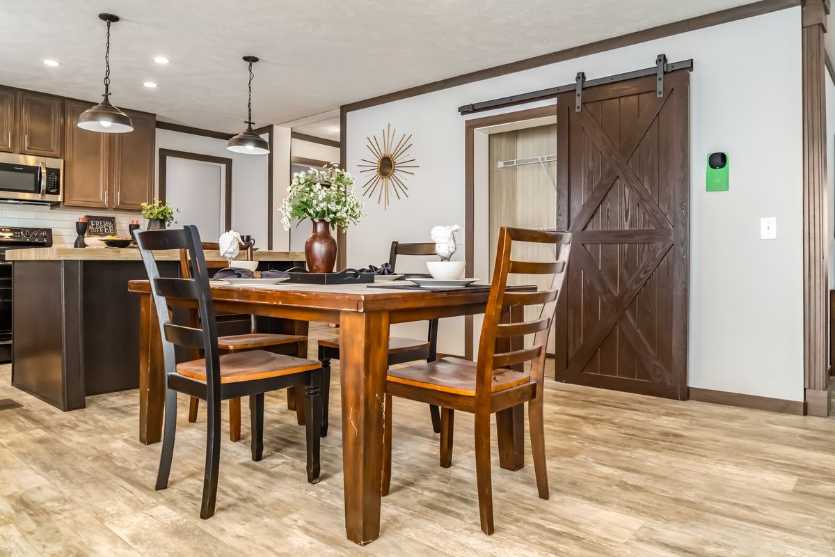 A kitchen with a dining table and chairs.
