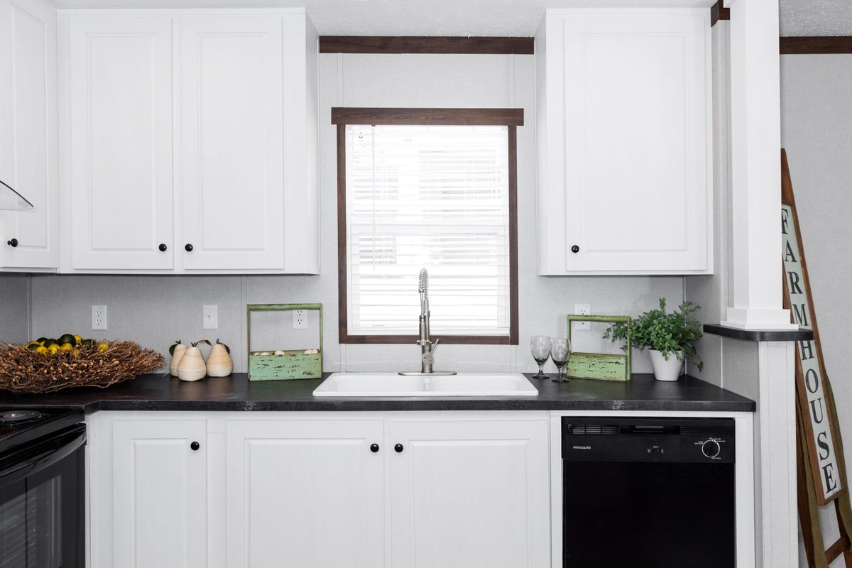 A kitchen with white cabinets and black appliances.