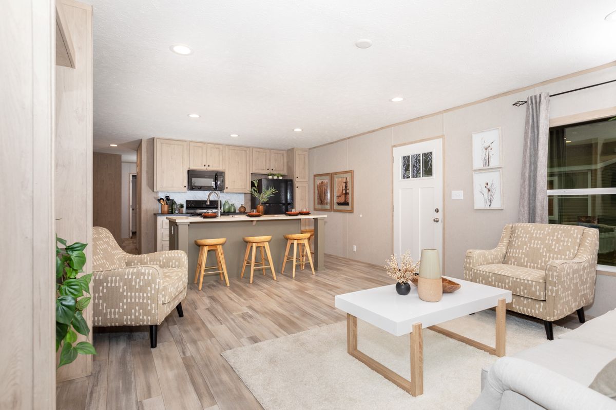 d64c7bd4-a56f-4ed6-8b8a-c2283c1d71d2 A living room and kitchen in a mobile home.