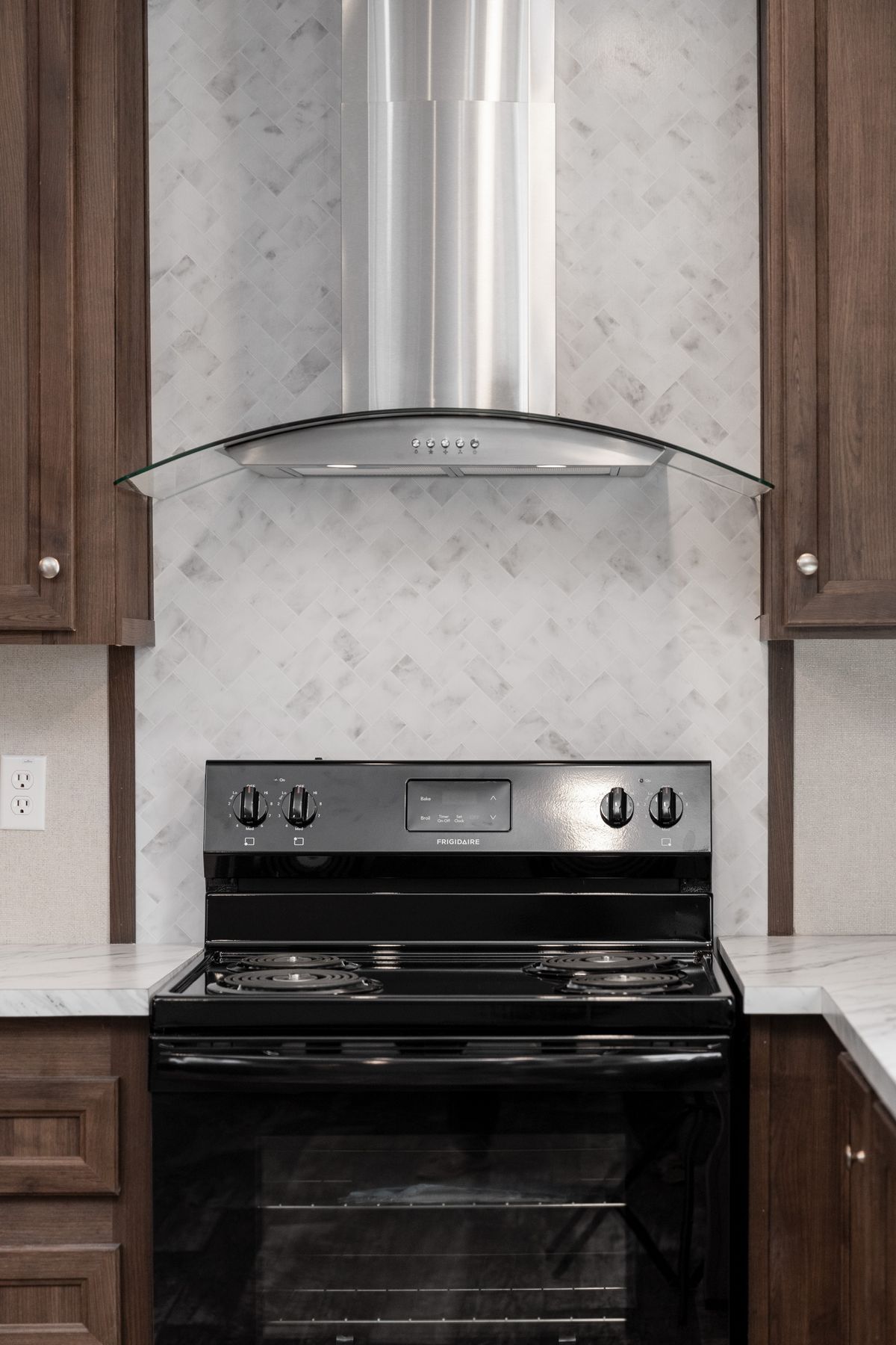 A kitchen with a stainless steel range hood.