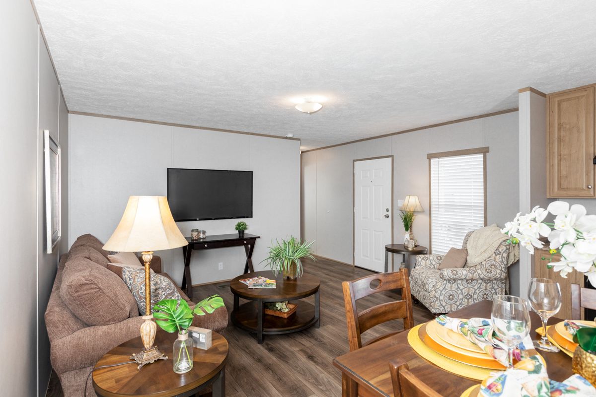 A living room and dining room in a mobile home.