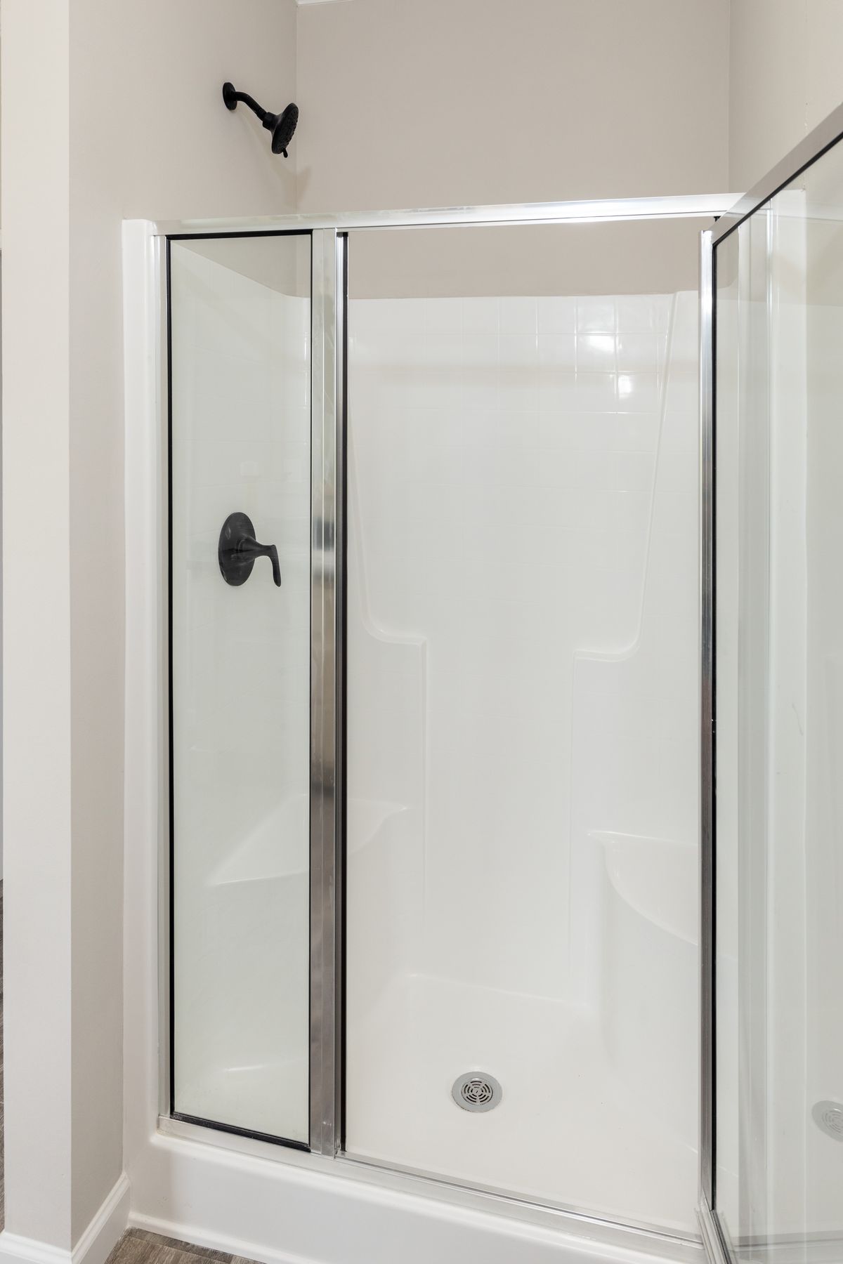 df4af446-0895-42b2-a395-dd32215e621c A white bathroom with a glass shower stall.