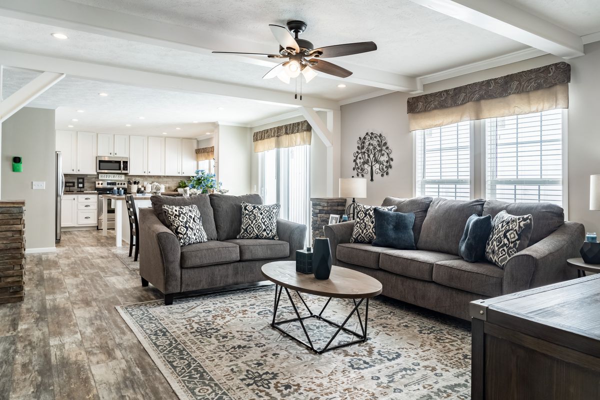 A living room with hardwood floors and a ceiling fan.